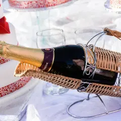 Sektflasche in einem Weidenkorb, neben einer Hochzeitstorte. Das Wein-Ablaufdatum ist hier unwichtig, die Freude zählt.