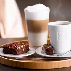 Ein Latte Macchiato mit viel Koffein, dazu ein Brownie und ein Stück Schokolade. Perfekt für eine Kaffeepause.