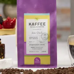 Kaffee-Genuss ohne Koffein: Entkoffeinierter Kaffee schmeckt anders, hier als ganze Bohne 100% Arabica mit Schoko-Aroma. Daneben ein feines Dessert.
