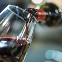 Rotwein wird in ein Glas gegossen. Die Frage, wie lange Rotwein offen haltbar ist, beschäftigt Genießer.
