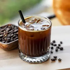 Erfrischender Cold Brew mit viel **cold brew koffein**. Eiswürfel und Kaffeebohnen daneben.