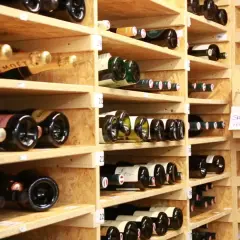 Weinregale voller Flaschen. Manche sind mit "Moët" beschriftet. Die Frage, wie lange ist Riesling haltbar, beschäftigt Weinliebhaber.