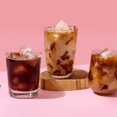 Drei Gläser mit erfrischendem Cold Brew Eiskaffee, einer mit dunklem Kaffee, die anderen beiden mit Milch und Eis.