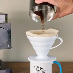 Kaffeezubereitung: Frisch gemahlener Kaffee rieselt in einen Filter. Die Frage, welcher Kaffee hat am meisten Koffein, beschäftigt jeden Morgen viele.