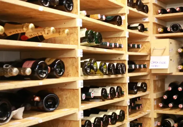 Weinregale voller Flaschen. Manche sind mit "Moët" beschriftet. Die Frage, wie lange ist Riesling haltbar, beschäftigt Weinliebhaber.