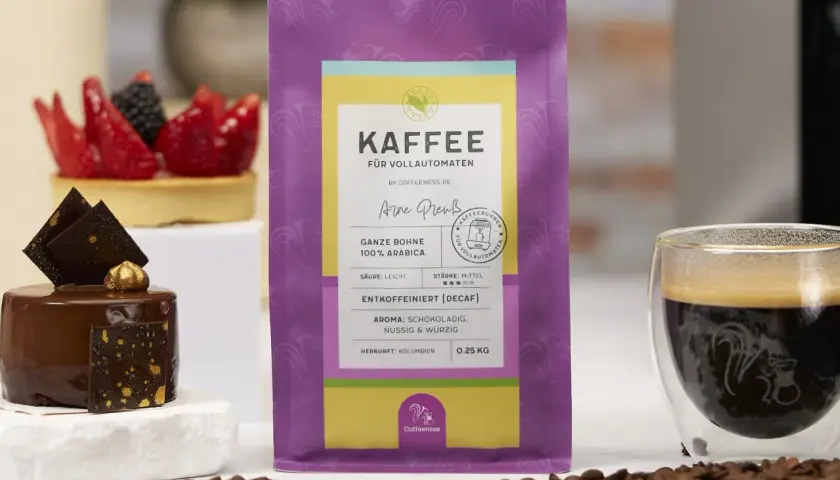 Kaffee-Genuss ohne Koffein: Entkoffeinierter Kaffee schmeckt anders, hier als ganze Bohne 100% Arabica mit Schoko-Aroma. Daneben ein feines Dessert.