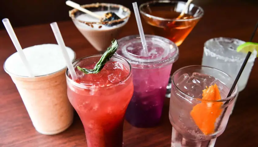 Verschiedene bunte Cocktails mit Eis und Garnituren. Ein cremiger Milchshake, ein roter Fruchtcocktail, ein lila Getränk und ein Gin Tonic. Gut zu wissen, dass Wodka glutenfrei ist!