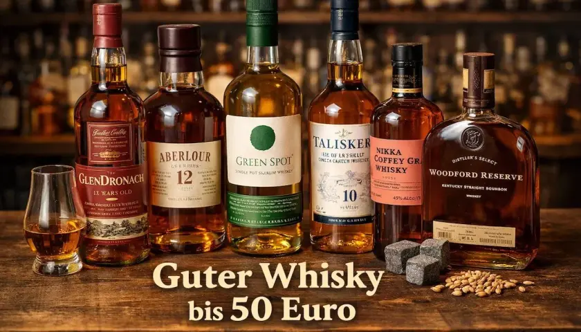 Sechs Flaschen edler Whiskys, darunter GlenDronach und Talisker, stehen bereit. Ein Glas mit bernsteinfarbener Flüssigkeit und Whiskysteine laden zum Genuss des besten Single Malts ein.