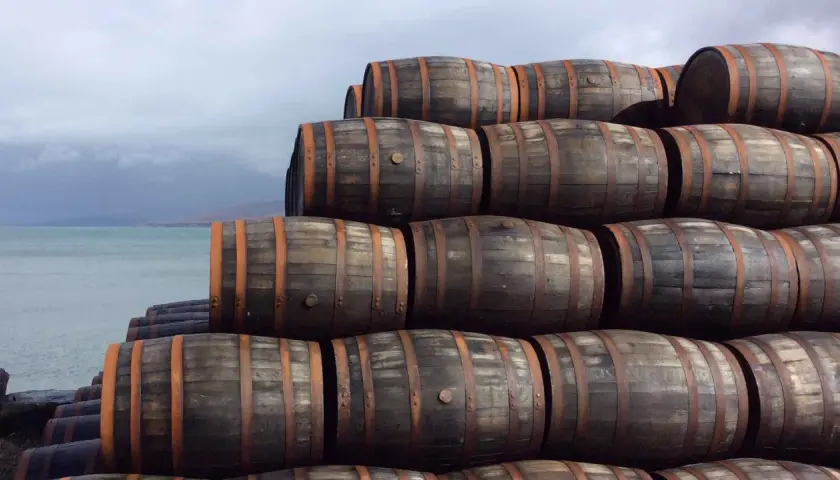 Stapel von Holzfässern am Wasser. Sie lagern dort, um die Reifung zu ermöglichen, was bedeutet, was bedeutet single malt.
