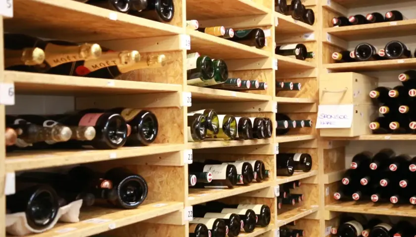 Weinregale voller Flaschen. Manche sind mit "Moët" beschriftet. Die Frage, wie lange ist Riesling haltbar, beschäftigt Weinliebhaber.