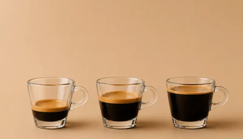 Drei Gläser mit unterschiedlichen Espresso varianten, von wenig bis viel Kaffee, mit cremiger Crema.