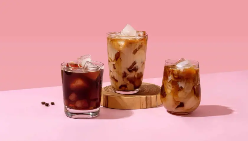 Drei Gläser mit erfrischendem Cold Brew Eiskaffee, einer mit dunklem Kaffee, die anderen beiden mit Milch und Eis.