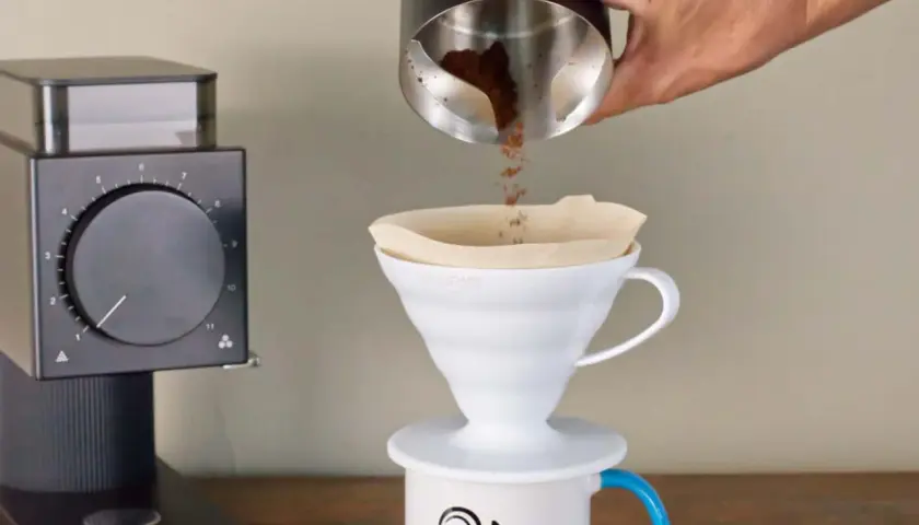 Kaffeezubereitung: Frisch gemahlener Kaffee rieselt in einen Filter. Die Frage, welcher Kaffee hat am meisten Koffein, beschäftigt jeden Morgen viele.
