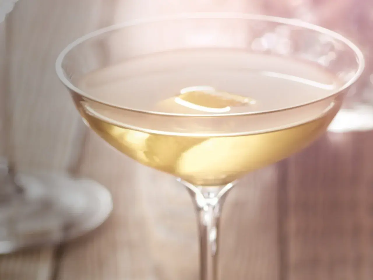 Ein Glas mit trockenem Wermut, garniert mit einer Zitronenscheibe, steht auf einem Holztisch.