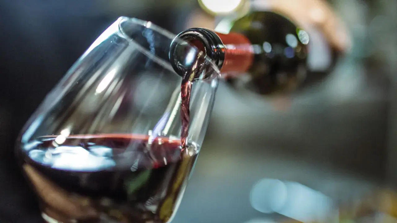 Rotwein wird in ein Glas gegossen. Die Frage, wie lange Rotwein offen haltbar ist, beschäftigt Genießer.
