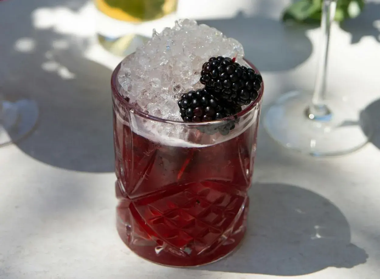 Erfrischender Brombeer-Cocktail mit zerstoßenem Eis und frischen Beeren. Perfekt für einfache Cocktails Rezepte.