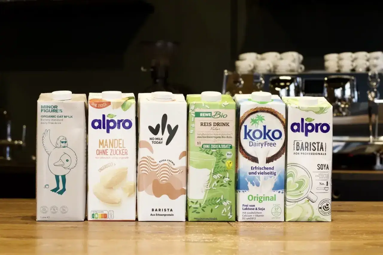 Sechs verschiedene pflanzliche Drinks: Hafer-, Mandel-, Reis-, Kokos- und Sojadrinks. Der Fettgehalt ist bei Milchersatzprodukten oft ein Thema für den perfekten Milchschaum.
