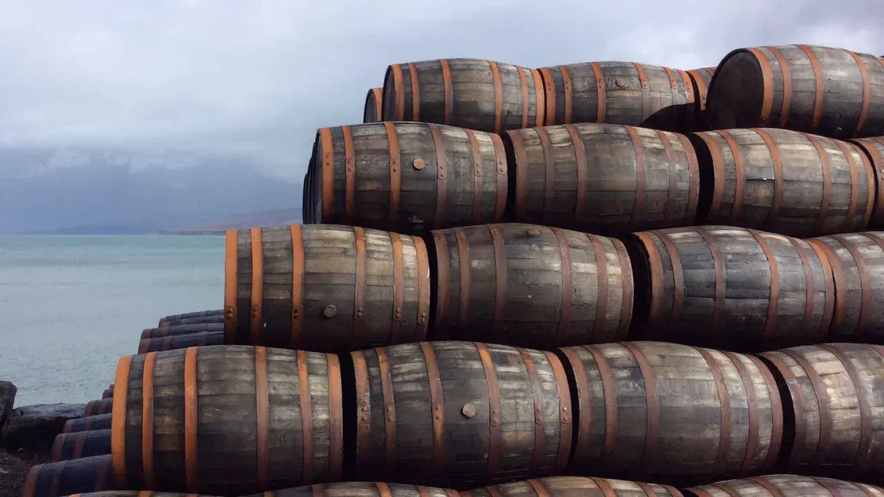 Stapel von Holzfässern am Wasser. Sie lagern dort, um die Reifung zu ermöglichen, was bedeutet, was bedeutet single malt.