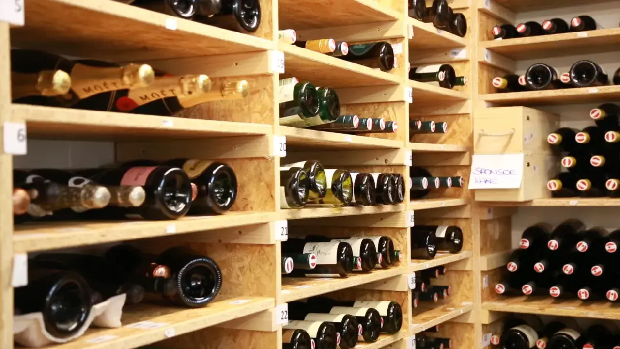 Weinregale voller Flaschen. Manche sind mit "Moët" beschriftet. Die Frage, wie lange ist Riesling haltbar, beschäftigt Weinliebhaber.