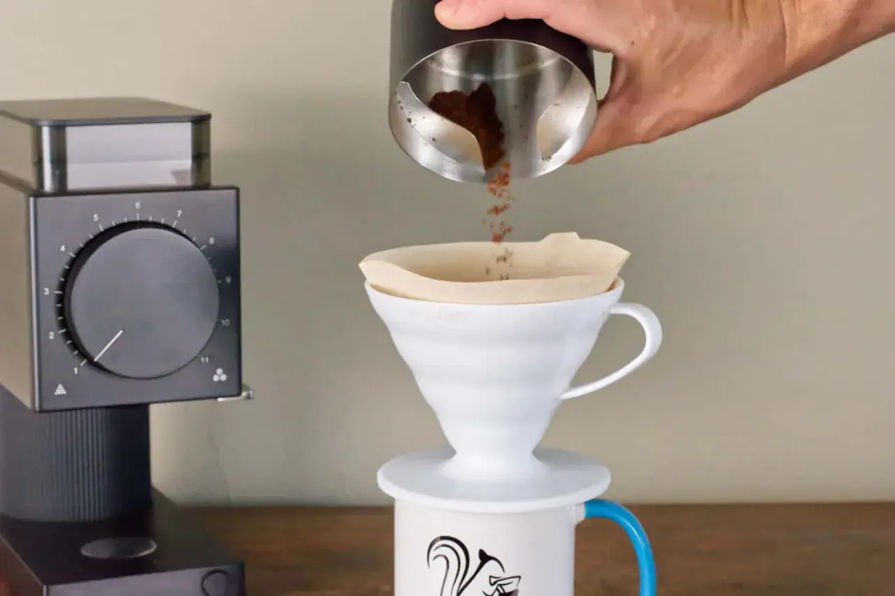 Kaffeezubereitung: Frisch gemahlener Kaffee rieselt in einen Filter. Die Frage, welcher Kaffee hat am meisten Koffein, beschäftigt jeden Morgen viele.