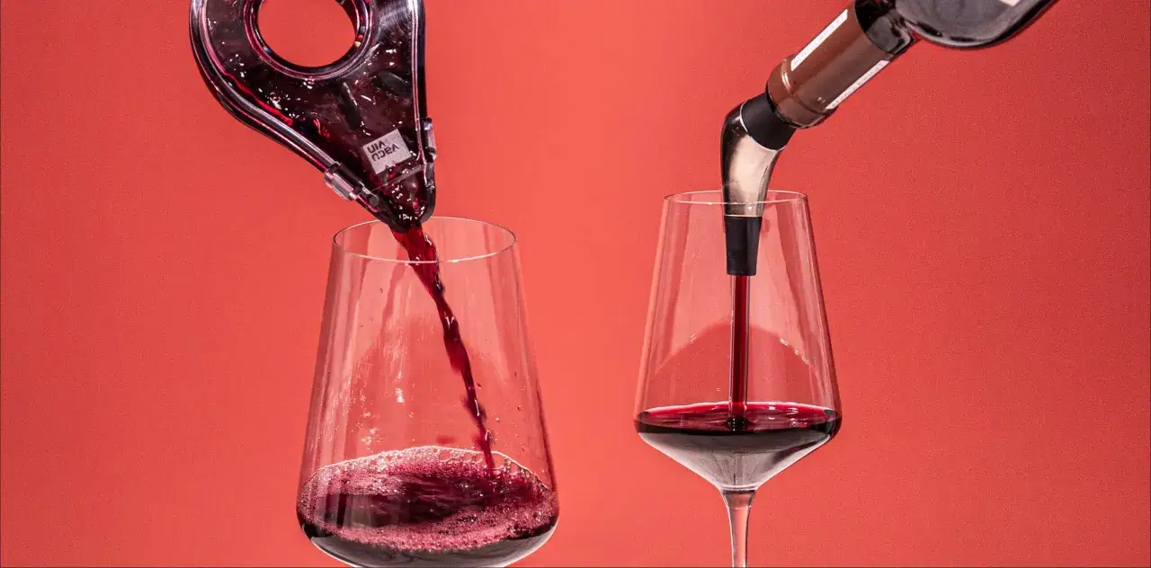 Rotwein wird in zwei Gläser gegossen: links aus einem Dekanter, rechts direkt aus der Flasche mit einem Ausgießer. So gelingt wein richtig einschenken.