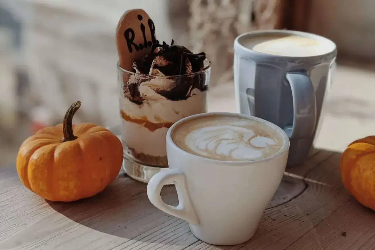 Kaffee mit Latte Art, ein Dessert im Glas und Kürbisse – perfekt für ein Pumpkin Spice Latte Starbucks Rezept.