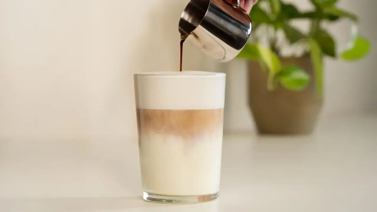 Ein Latte Macchiato mit viel Schaum und dem nötigen Koffein wird zubereitet.