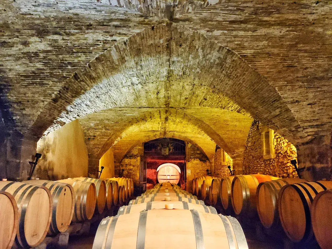 Holz-Fässer reifen in einem historischen Keller, der an Châteauneuf-du-Pape erinnert.
