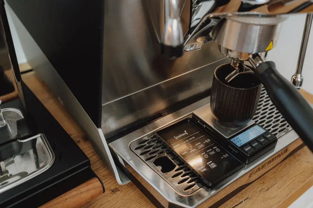 Espressozubereitung: Eine Tasse steht auf einer Waage, die das Gewicht misst. Die Frage