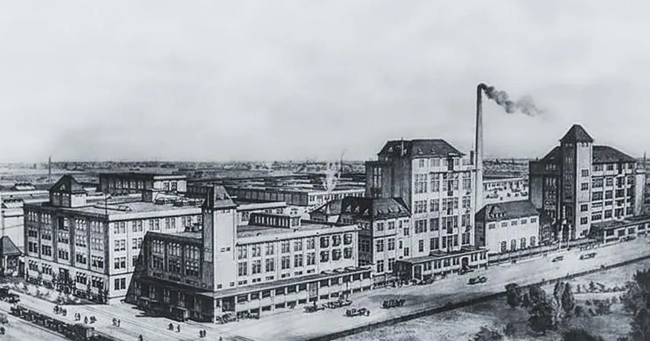 Historische Fabrikanlage, die das Kaffee HAG entkoffeiniert Verfahren zeigt. Rauch steigt aus einem Schornstein auf.